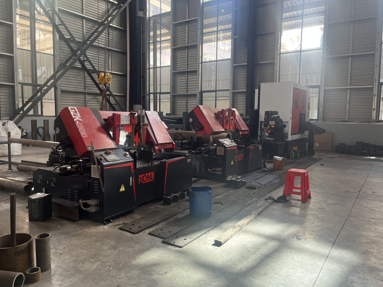 Band saws cutting steel bars to forging weight